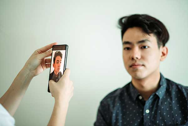 A student poses for a photo that his friend is taking.